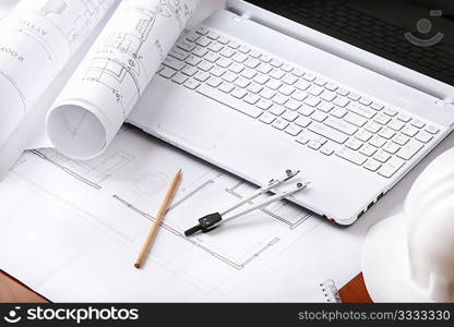 concept with white laptop and blueprints(all prints are fake) with hardhat, selective focus