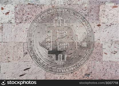 conceptual background ore wallpaper: a wall of natural pink tuff with a symbolic image of bitcoin, crypto currency, new digital money in cyber world