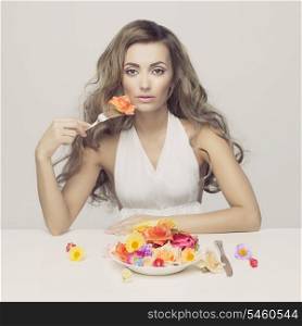 Conceptual fashion photo of young lady eating flowers