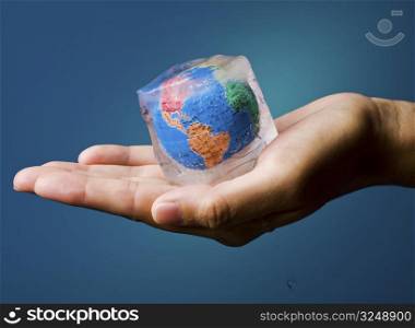 Conceptual image about saving Earth. The globe frozen into an icecube thrawing.