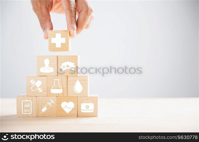 Conceptual image, Hand holds wooden block with healthcare and medical icons. Portrays safety, health, and family well-being, symbolizing pharmacy, heart care, and happiness. health care concept