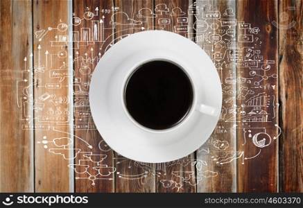 Conceptual image of cup of coffee with business sketches at background