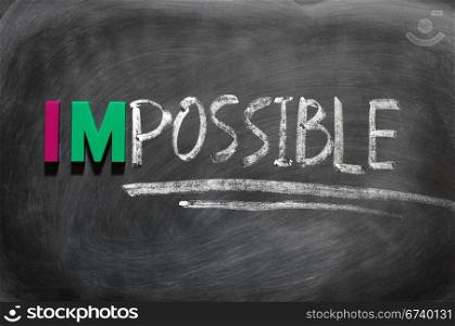 Conceptual image of the word impossible written in chalk on a smudged blackboard