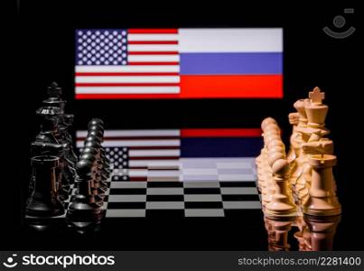 Conceptual image of war between United States and Russia using chess pieces and national flags on a reflective background