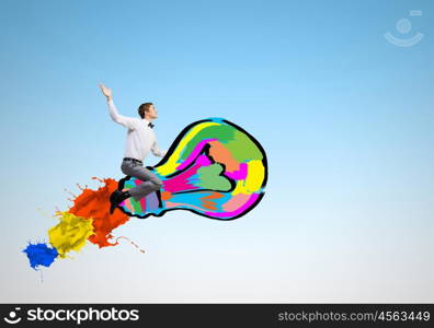 Conceptual image of young businessman riding light bulb. Master of creativity