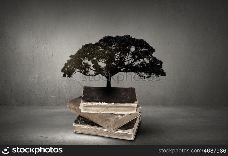 Conceptual image with green tree growing from book. Reading and self education