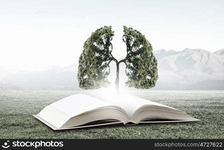 Conceptual image with green tree growing from book. Reading and self education