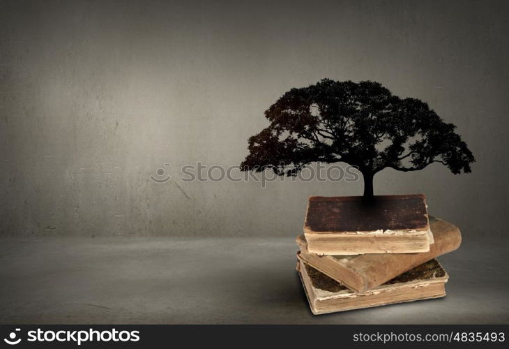 Conceptual image with green tree growing from book. Reading and self education