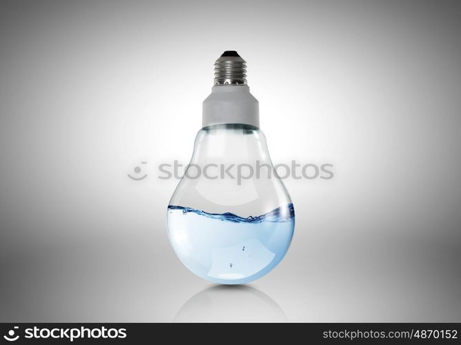 Conceptual image with light bulb filled with clear water. Light bulb with water