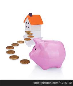 conceptual image with piggy bank, coin and house
