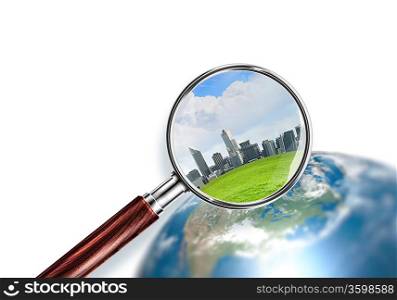 Conceptual mini planet with skyscrapers on it under a magnifying glass. Elements of this image are furnished by NASA