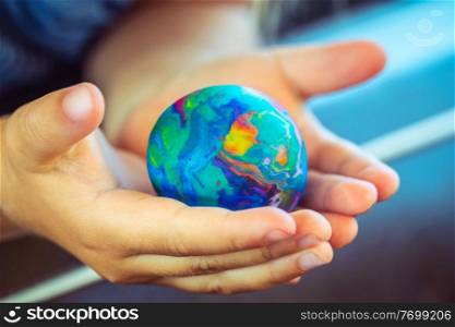 Conceptual Photo of a Saving the Planet, Babie’s Hands Holding Little Earth, Made of Plasticine, Future of the Planet, Pollution Free.