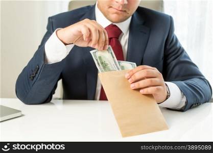 Conceptual photo of bribed politician taking envelope with money