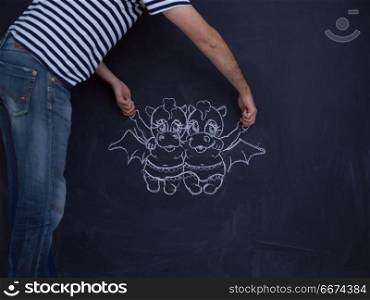 Conceptual photo of future dad drawing his imaginations about the future life with children on chalk board. future dad drawing his imaginations on chalk board