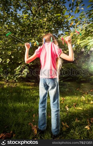 Conceptual photo of girl hanging on clothesline