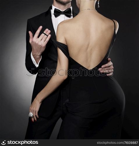 Conceptual photo of sexy elegant couple in the evening suit and dress. dancing lovers pose in photography studio.
