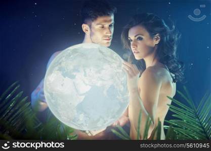 Conceptual photo of the couple holding shiny Earth