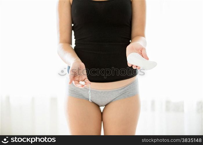 Conceptual photo of young woman choosing menstrual pad rather than tampon