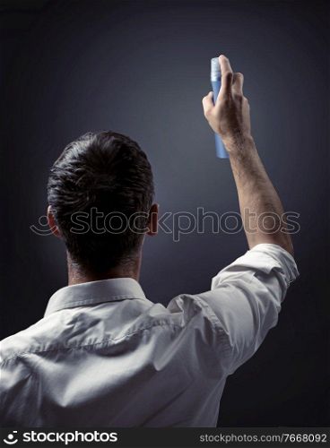 Conceptual picture of a guy pointing spray on a wall
