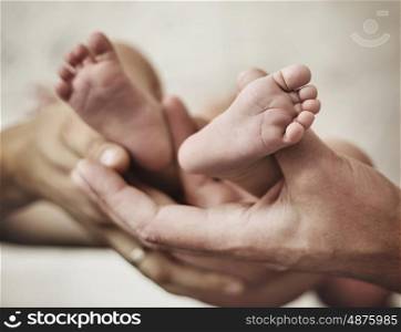 Conceptual picture of parents golding a baby's little feet