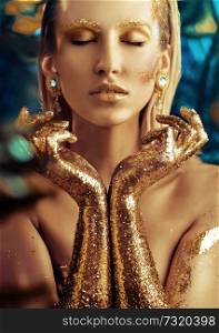 Conceptual portrait of a glittering golden woman