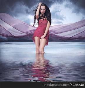 Conceptual portrait of an elegant lady posing in the lake water
