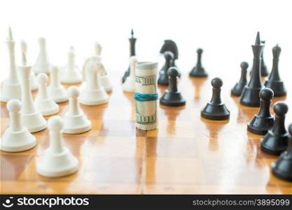 Conceptual shot of twisted money on wooden chessboard