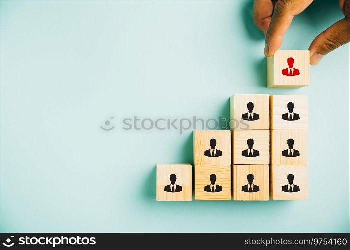 Conceptual stock photo depicting human resources talent management and recruitment. Person icons on wooden cube block symbolize teamwork and organization. Woman exemplifies leadership in business.
