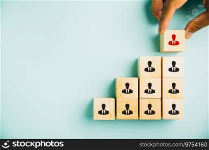 Conceptual stock photo depicting human resources talent management and recruitment. Person icons on wooden cube block symbolize teamwork and organization. Woman exemplifies leadership in business.