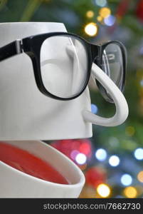 Conceptual Teacup with Eyeglasses Laughing with holidays background