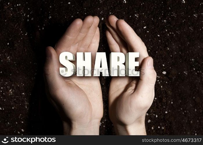 Conceptual word in palms. Male hands on soil background showing in palms word share