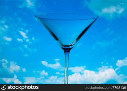 conceptually illuminated martini glass against the sky