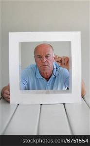 Concerned bald man sat with frame