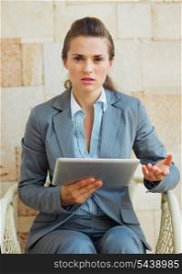 Concerned business woman working with tablet pc on terrace