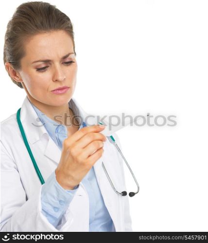 Concerned doctor woman looking on thermometer