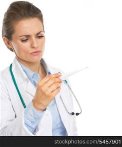 Concerned doctor woman looking on thermometer