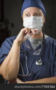 Concerned Female Doctor or Nurse Wearing Protective Face Mask and Holding Protective Eye Glasses.