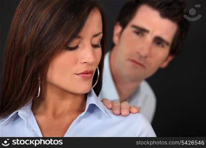 Concerned man touching his wife&rsquo;s shoulder