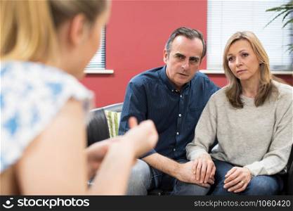 Concerned Mature Couple Talking With Female Counselor