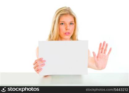Concerned young girl holding blank paper and showing stop gesture&#xA;