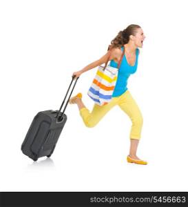 Concerned young tourist woman with wheel bag rushing