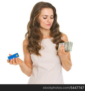 Concerned young woman with credit card and dollars