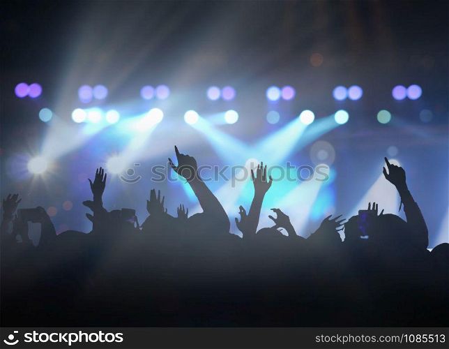 Concert crowd in silhouettes of Music fanclub with show hand action which follow up the songer at the front of stage with follow light, musical and concert concept