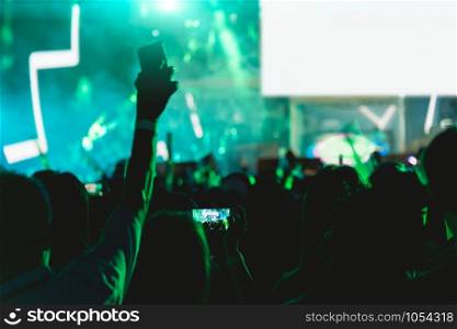 Concert crowd music festival, using mobile smart phone on stage lights