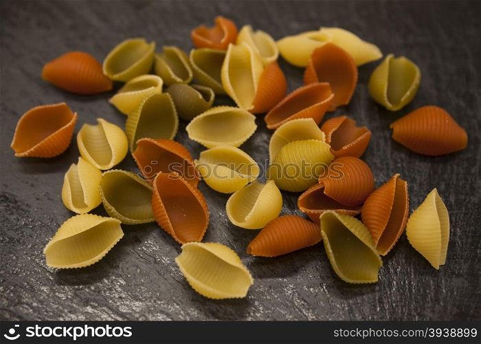 Conchiglioni Italian pasta from durum wheat on stone background, closeup.