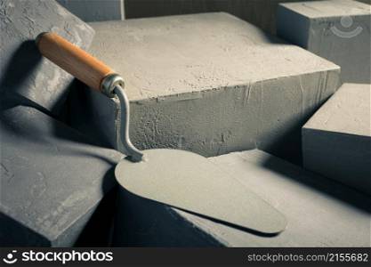 Concrete cube or construction brick and trowel. Construction concept and mason