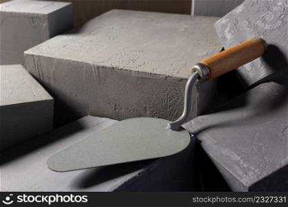 Concrete cube or construction brick and trowel. Construction concept and mason