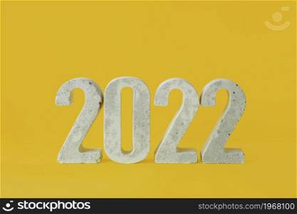 concrete numbers 2022 on a yellow background.