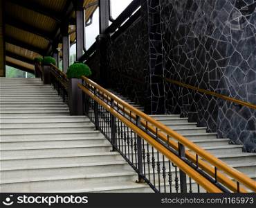 Concrete staircase with wooden railing. Bottom view