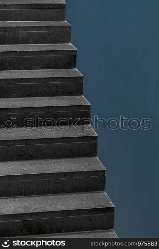 Concrete stairs and blue wall inside a modern building. Home interior staircase and a blank wall